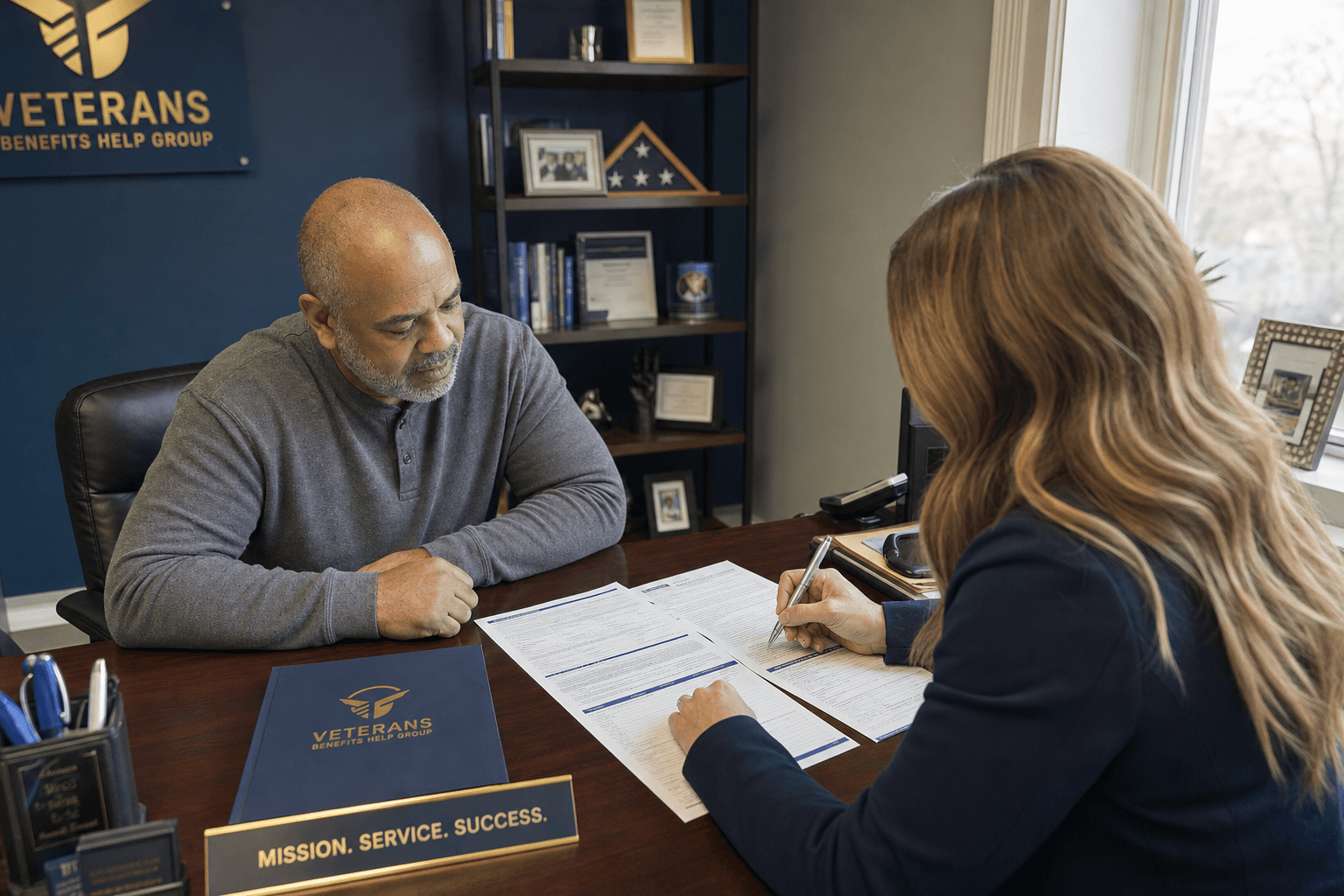 Veteran and claims specialist reviewing a document together at a desk with natural lighting and navy and gold tones